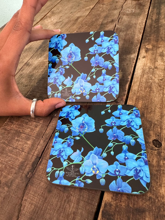shakinaart UNIQUE CENTRIC fine art Blue VELVET orchids on black coaster: A stunning arrangement of vibrant blue orchids bouquet resting on a sleek black coaster. PERFECT wedding gift BRIDE BRIDAL SHOWER for protecting surfaces from drink spills. DAVID LYNCH COASTERS
